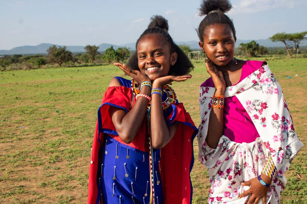 Two girls smile at an Alternative Rites of Passage ceremony in Kajiado, Kenya, 2024