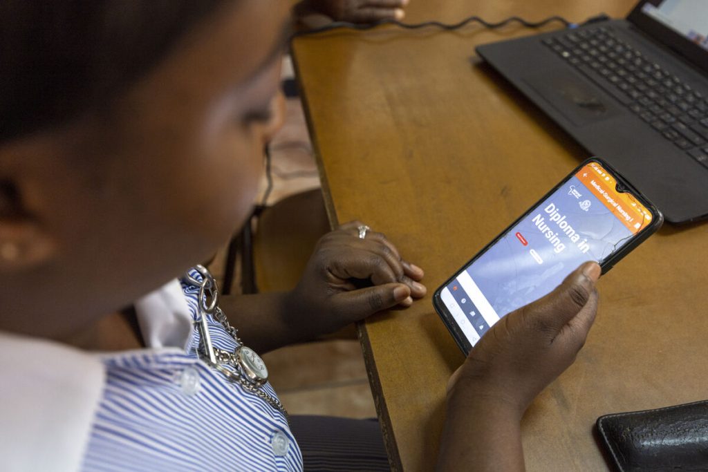 Sibusisiwe Munkonde uses her phone to undertake an abridged Diploma in Nursing in Zambia. (c) Amref Health Africa/David Brazier